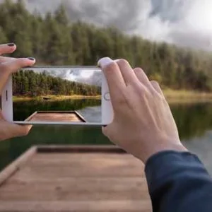 a person taking a picture of a lake