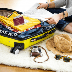 a person packing clothes in a suitcase