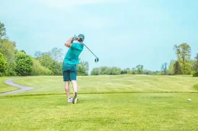 a person swinging a golf club