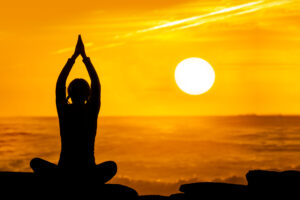 Woman doing Yoga at Sunset