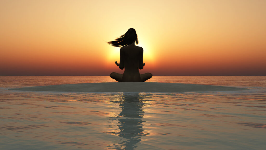 Woman Sitting with crossed legs doing a yoga pose with the run setting in the distance