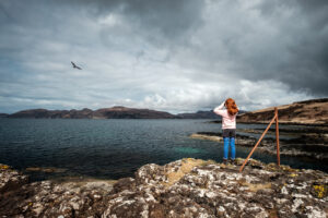 Scottish girl observing a buzzard on the Isle of Mull