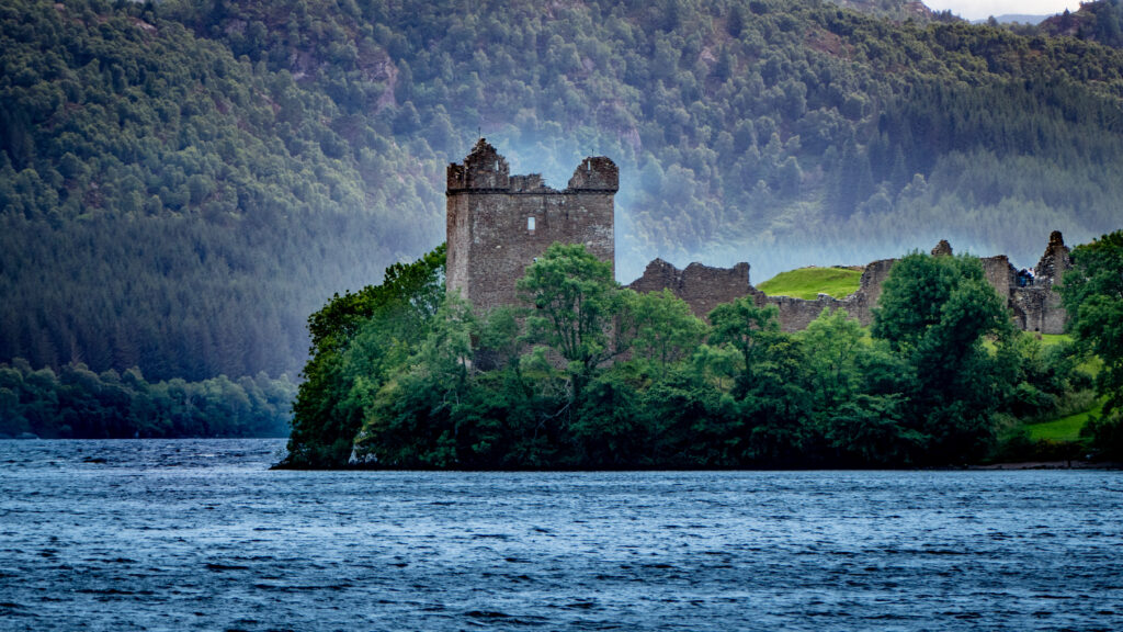 A view of Urquhart Castle Ruins from the waters of Loch ness, on a cloudy day