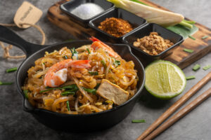 Close up Thai Fried Noodles and Seasoning with Lemon There is a brown paper to tag the word THAILAND. and Famous Street Food of Thailand.
